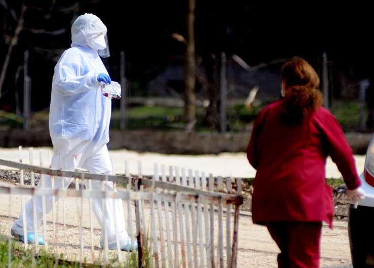 Man in protective suit carying medical samples