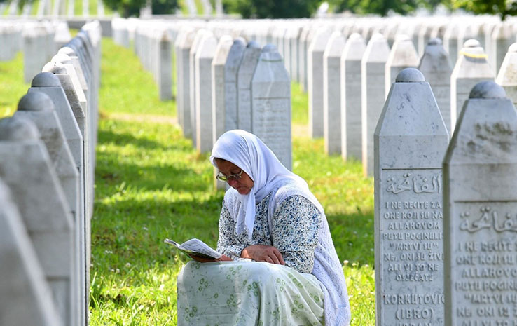Woman reading a book at a graveyard