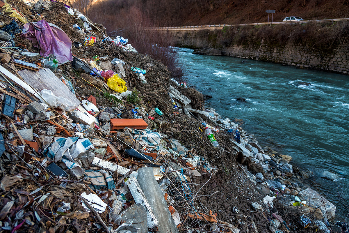 Фотографија на која се гледа отпад покрај река.